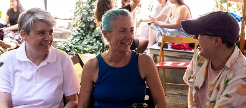 3 osebe se pogovarjajo in smejijo na lezbičnem pikniku, zaključnem dogodku festivala Lezbična četrt